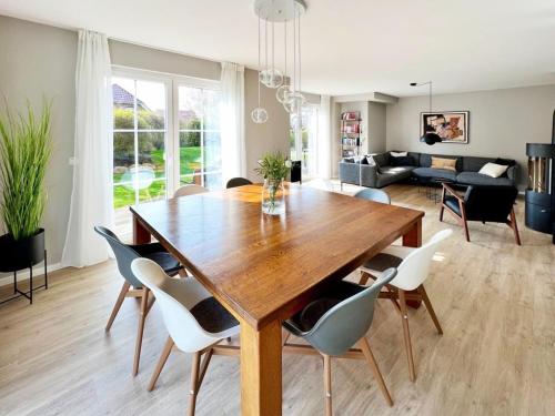 a dining room and living room with a wooden table and chairs at "Sonnenliebe" Ferienhaus in Groß Schwansee