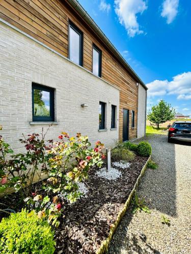 a brick building with a garden in front of it at L'échappée Belle by J&J Durbuy Area in Clavier
