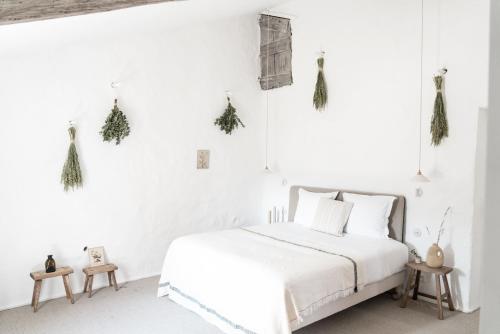 a white bedroom with a white bed and white walls at La Bastide du Mourre in Oppède