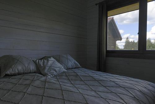 a bed in a room with a window at Dvarčėnų dvaras in Dvarčėnai