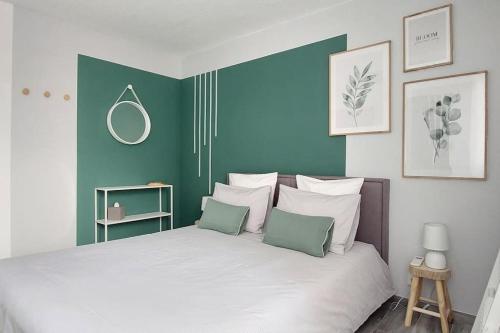 Schlafzimmer mit einem Bett mit grünen und weißen Wänden in der Unterkunft Appartement T4 centre-ville, plage à 5 min à pied in Sainte-Maxime