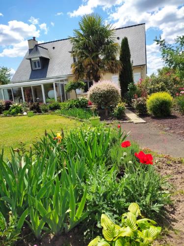 una casa con un jardín con flores en el patio en Chambres Le Mans 24 heures, en Arnage