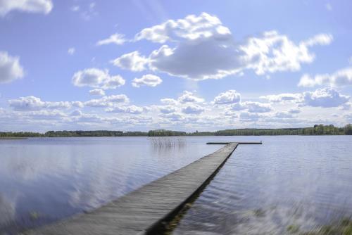 a dock in the middle of a large lake at Dvarčėnų dvaras in Dvarčėnai
