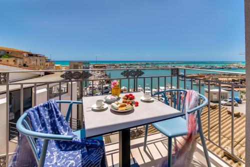 a table and chairs on a balcony with a view of the ocean at RoccaRegina Hotel in Sciacca