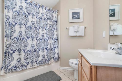 a bathroom with a blue and white shower curtain at A Sandy Situation in Myrtle Beach