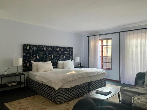 a bedroom with a large bed and a couch at Le Must Residence in Upington