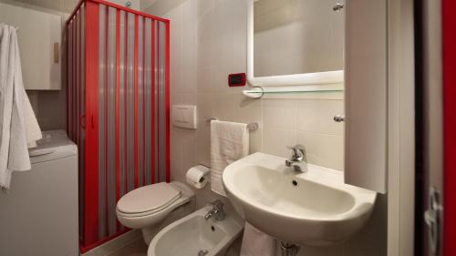 uma casa de banho com um WC branco e um lavatório. em Dimora in Alba em Alba