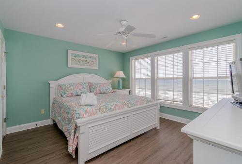 Schlafzimmer mit einem Bett und blauen Wänden und Fenstern in der Unterkunft Beach Retreat in Myrtle Beach