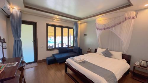 a bedroom with a large bed and a blue chair at Sapa Eco Villas & Spa in Sa Pa