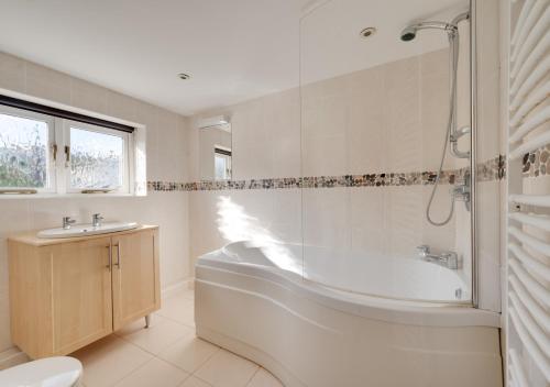 a white bathroom with a tub and a sink at Carthew House Carthew Way in St Ives