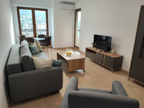 een woonkamer met 2 banken en een tv bij Grand View Apartment in Skopje