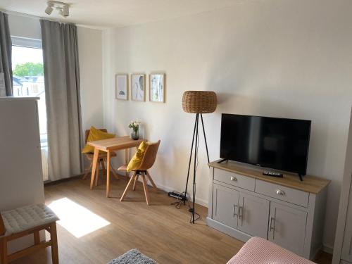 a living room with a flat screen tv on a dresser at Hans & Franz Zimmervermietung in Schwerin