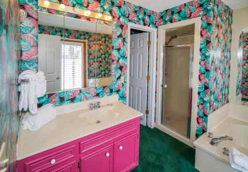 W łazience znajduje się różowa toaletka i duże lustro. w obiekcie Seascape w mieście Myrtle Beach