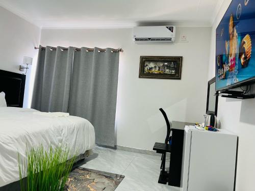 um quarto com uma cama e uma cortina cinzenta em Maun Nest Hotel em Maun