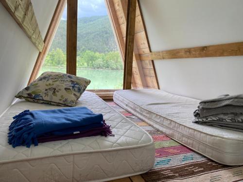 two beds in a room with a large window at Kamp jezero Stari Brod 