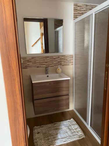 a bathroom with a sink and a shower with a mirror at Casa Muscettola in Leporano