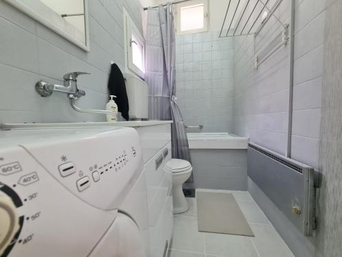 a white bathroom with a toilet and a shower at Angelina apartmani. in Vračar (historical)