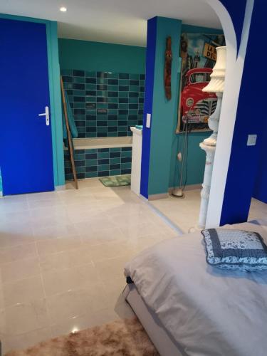 um quarto com uma cama e uma parede azul em Mimosas 'Hill em Mandelieu-la-Napoule