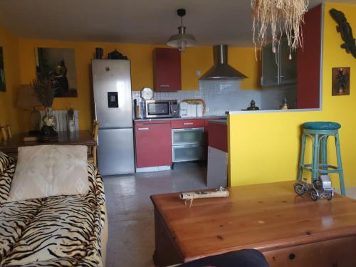 uma cozinha com um frigorífico e uma mesa num quarto em Mimosas 'Hill em Mandelieu-la-Napoule