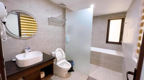 a bathroom with a sink and a toilet and a mirror at Sapa Eco Villas & Spa in Sa Pa