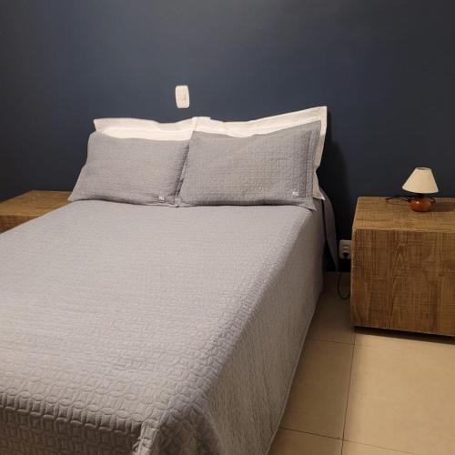 een slaapkamer met een bed met een blauwe muur bij Residencial com CHURRASQUElRA! in Bento Gonçalves