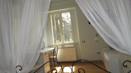 a bedroom with a bed and a window with curtains at Arco dolce Arco in Benevento