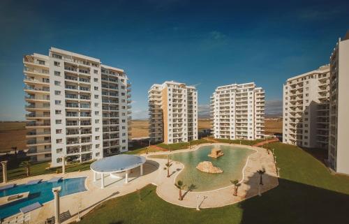 an aerial view of a pool in the middle of buildings at Spacious One Bedroom Apartment in Caesar Resort & SPA, Long Beach in Perivolia tou Trikomou