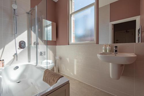 a bathroom with a tub and a sink and a shower at Luxury flat next to town centre Long-stay discount in Reading