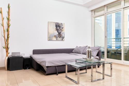 ein Wohnzimmer mit einem Sofa und einem Tisch in der Unterkunft 1BR for 4 guests in Marina Crown in Dubai