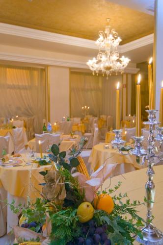 a dining room with white tables and a chandelier at Hotel Terme Principe in Abano Terme