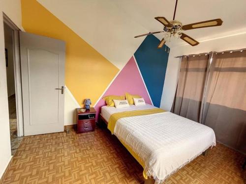 1 dormitorio con 1 cama y ventilador de techo en Villa Les 12 Zicaques, en Saint-Joseph