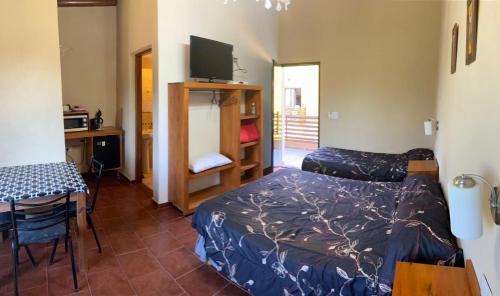a room with two beds and a table and a desk at Apart hotel la soñada in Federación