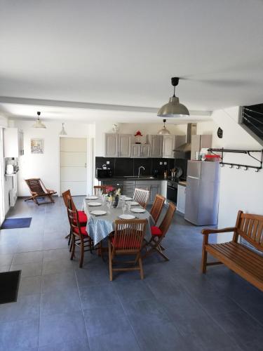une salle à manger et une cuisine avec une table et des chaises dans l'établissement GITE LA BLANCHE LONGERE, à Compertrix