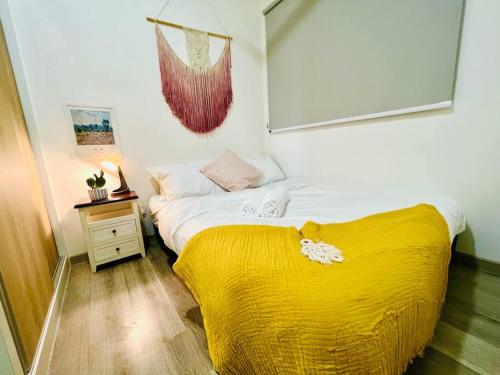 Un dormitorio con una cama con una manta amarilla. en Bohemian Style Home@JB Southkey Mosaic 8-12paxWIFI, en Johor Bahru
