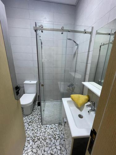 a bathroom with a shower and a sink and a toilet at Good Life Yellow and Ocean Holiday Apartments in Taoutiet el Bioute
