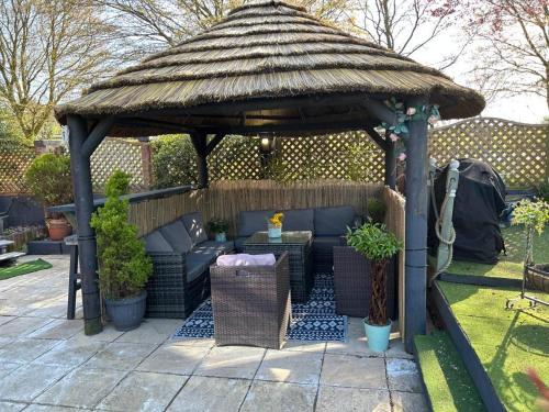 a gazebo with a couch and chairs in a yard at Home in the Vale Of Evesham in Pershore