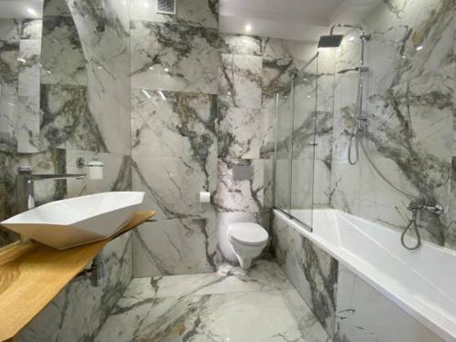 a marble bathroom with a sink and a toilet and a tub at Villa U Skupniów Suche-Zakopane in Poronin