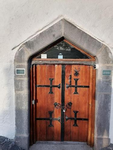 a large wooden door in a stone arch way at The Burren Art Gallery built in 1798 in Tubber