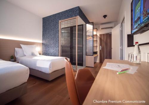 a hotel room with two beds and a table at Paxton Paris MLV in Ferrières-en-Brie