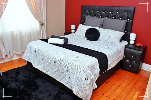 a bedroom with a large bed with a black headboard at THE GLOBAL LINK HUB in Pretoria