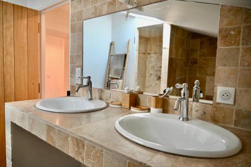 a bathroom with two sinks and a large mirror at Mas de Chassole Les Gîtes de l'Aurore in Ongles