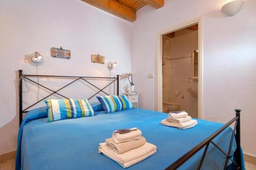 a bedroom with a blue bed with towels on it at Fortezza - Hvar Old Town Apartment in Hvar