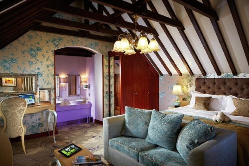 a bedroom with a bed and a couch in a room at South Lodge in Lower Beeding
