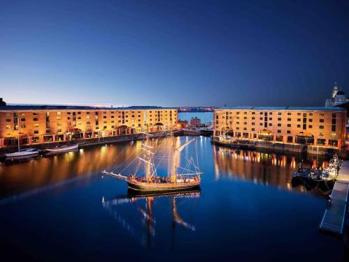 a boat in the water in front of some buildings at Liverpool City Centre Apartment in Liverpool