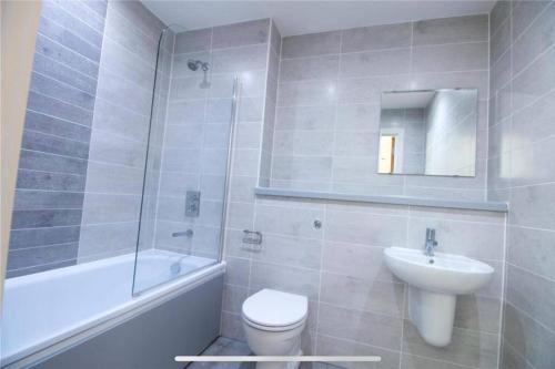 a bathroom with a sink and a toilet and a bath tub at Liverpool City Centre Apartment in Liverpool