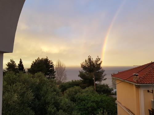 a rainbow in the sky over the ocean at Levante Breeze in Xirokástellon