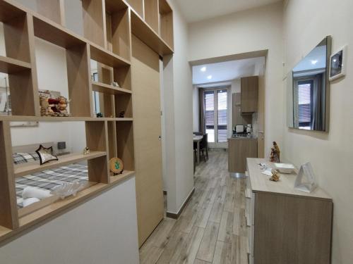 eine Küche mit Holzregalen und einem Waschbecken im Zimmer in der Unterkunft Casa Paolina in Militello in Val di Catania