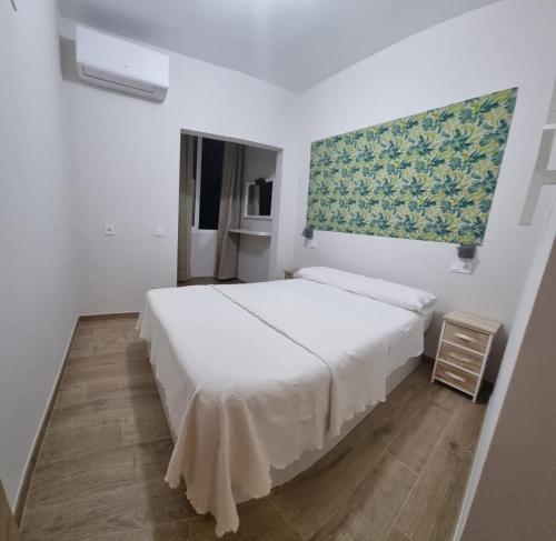 a bedroom with a white bed and a window at Apartamento Cuevas in Fuengirola