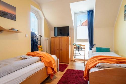 um quarto com duas camas e uma televisão e uma janela em Strandpark-Grossenbrode-Haus-Windrose-Wohnung-14 em Grossenbrode