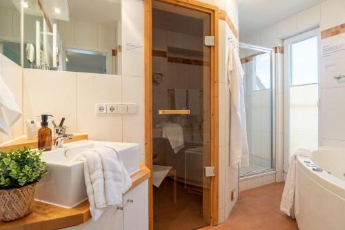 uma casa de banho branca com um lavatório e um chuveiro em Strandpark-Grossenbrode-Haus-Windrose-Wohnung-14 em Grossenbrode